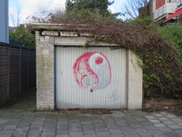 828713 Gezicht op een vervallen garagebox in de Verenigingdwarsstraat te Utrecht, met graffiti van het I Tjing-symbool ...